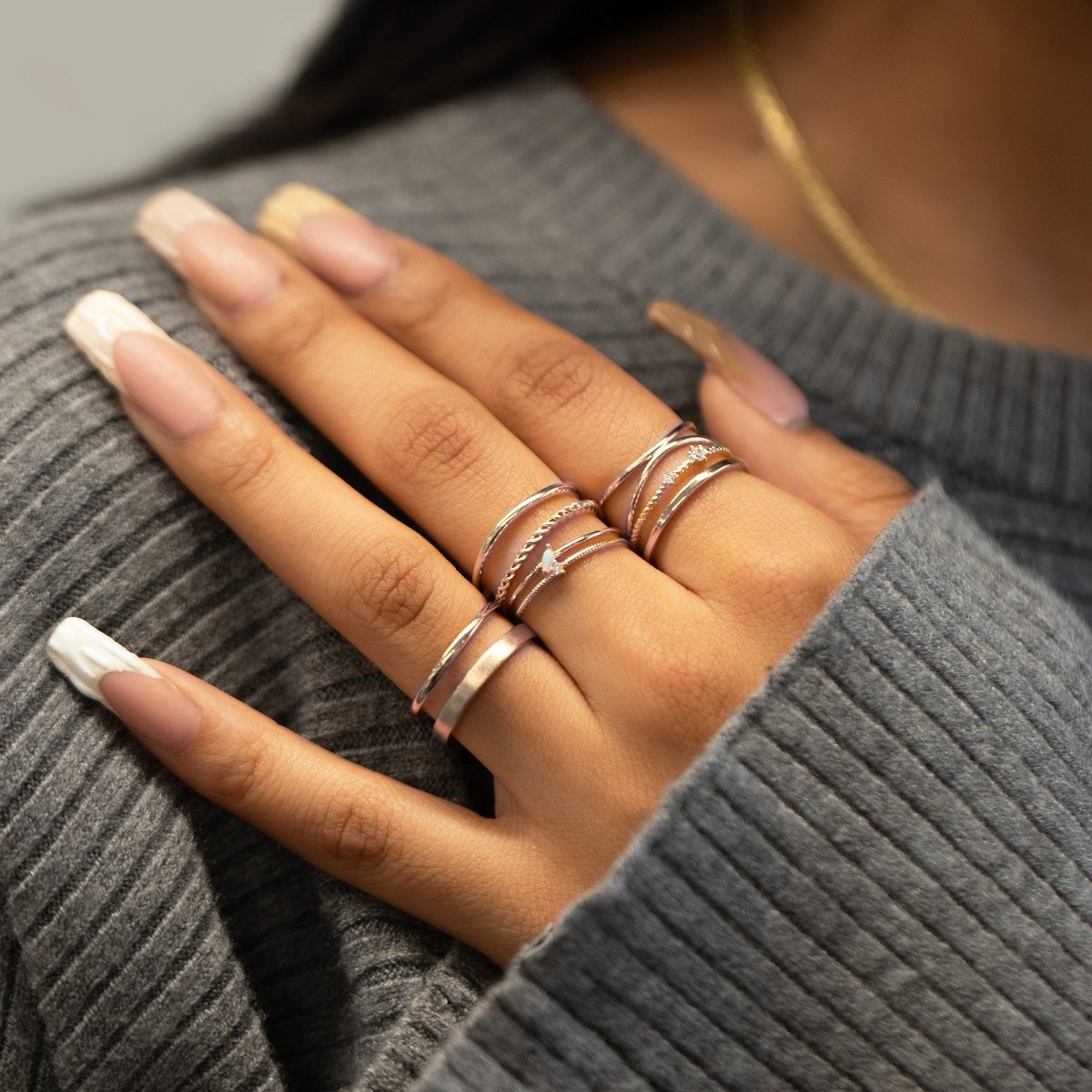 Silver rope stacking rings with clear stones, shown layered on a model's fingers
