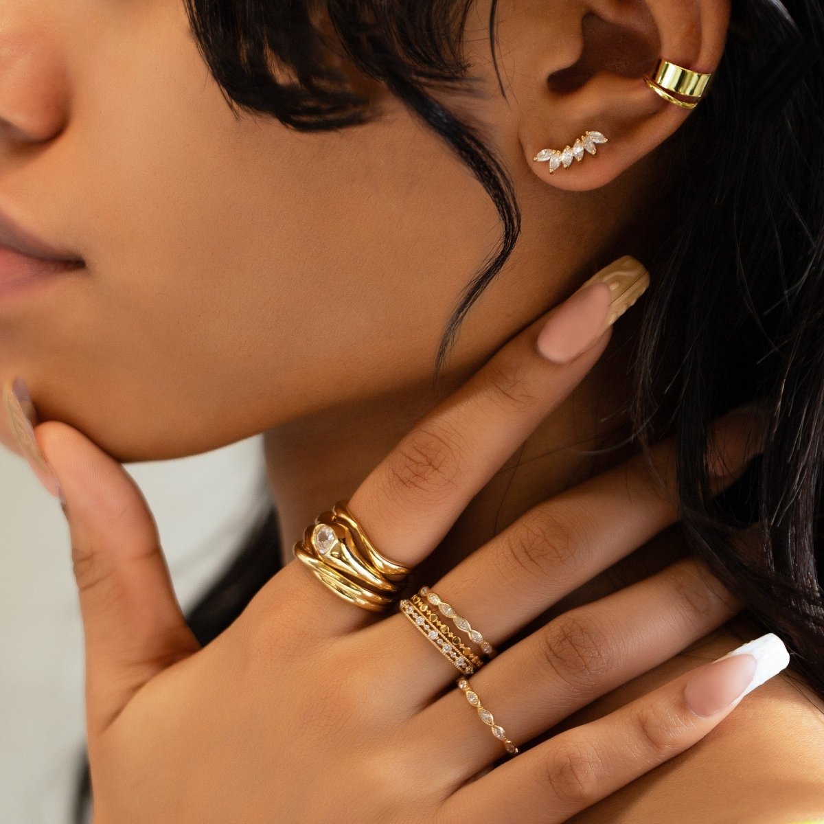 Gold vermeil eternity stacking ring with white zirconia, stacked on a model's finger near her ear