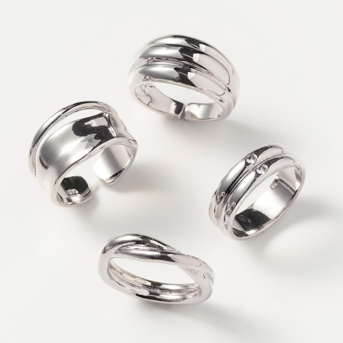 Sterling silver dome statement ring with a ridged band, shown with other silver rings on a white background