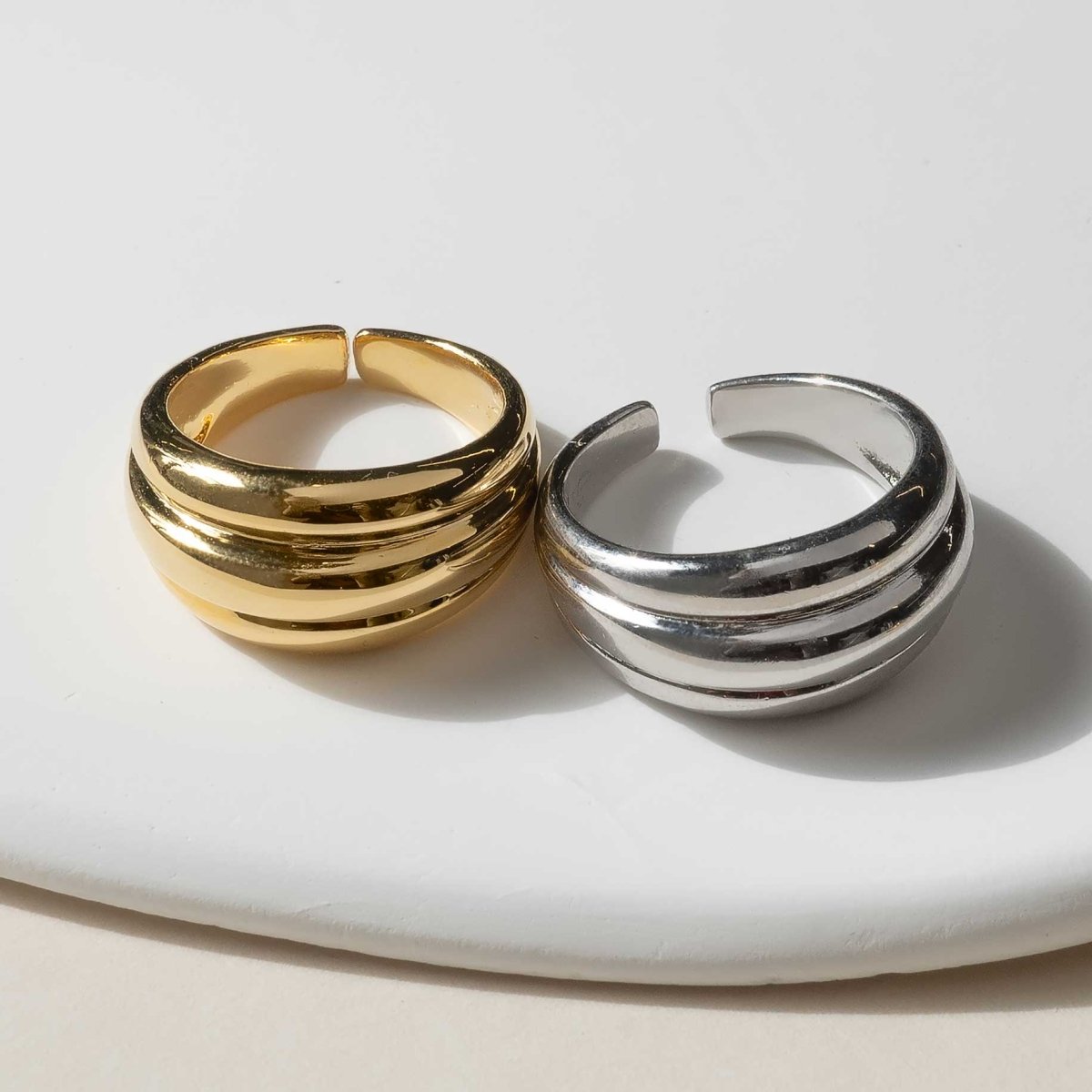 Gold vermeil and sterling silver dome statement rings with ridged bands, on a white background