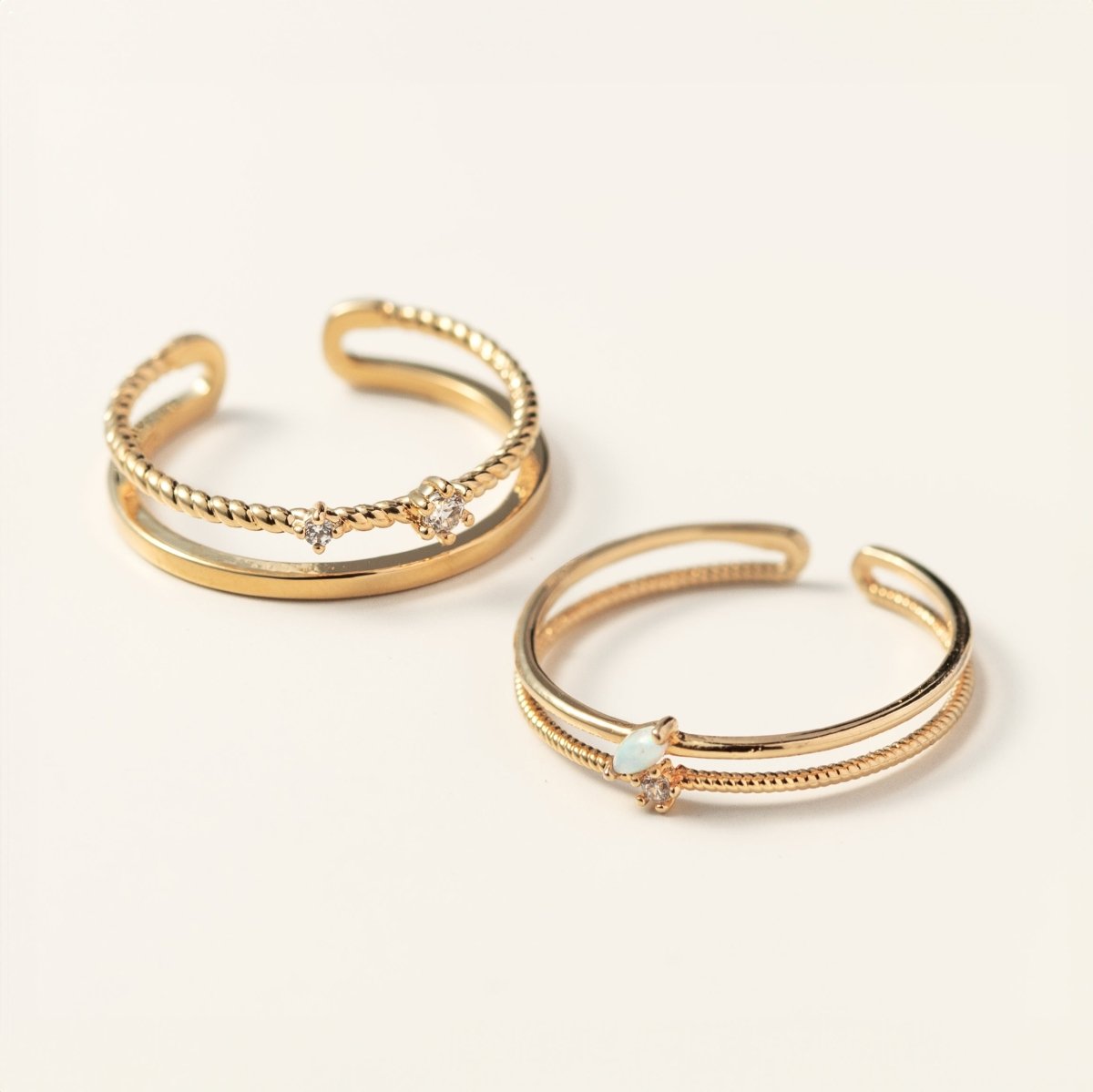 Two gold vermeil rope stacking rings with white zirconia stones, shown on a cream background