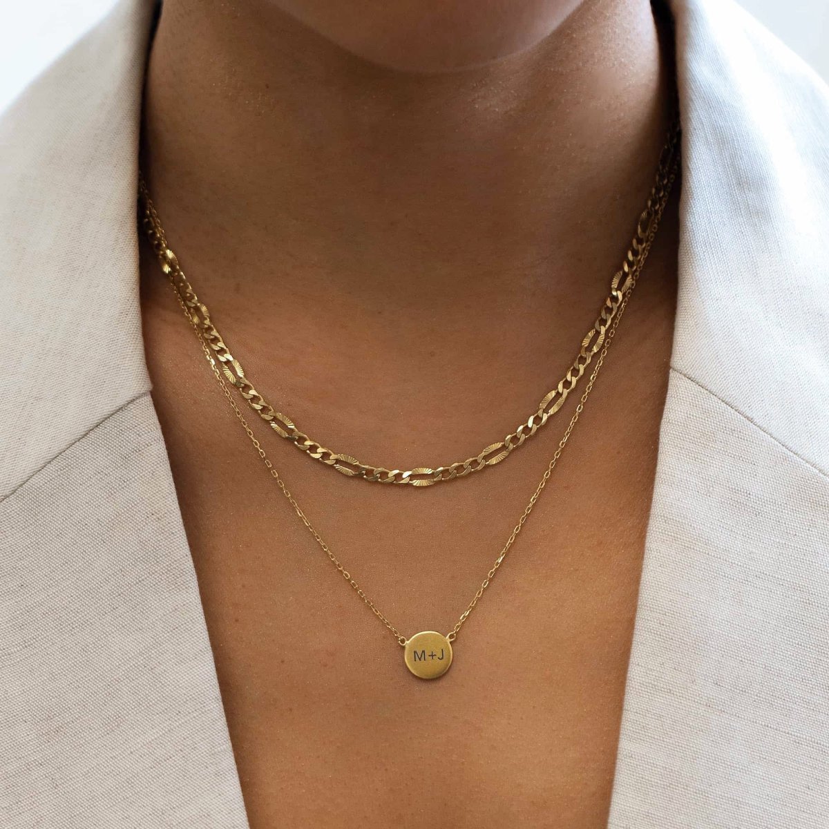 Gold vermeil engravable disc necklace engraved with initials, layered on a model's neckline