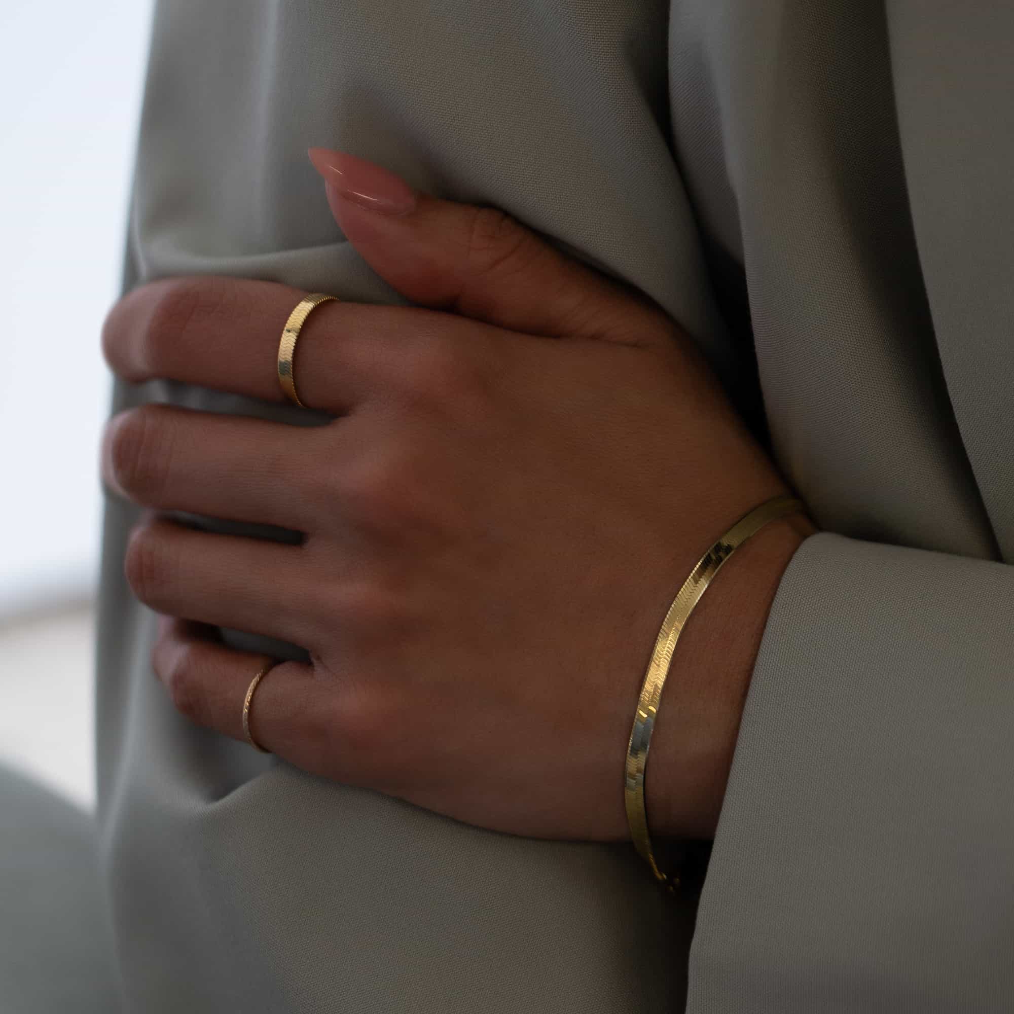 Gold vermeil herringbone chain stacking ring shown on a model's finger with matching bracelet