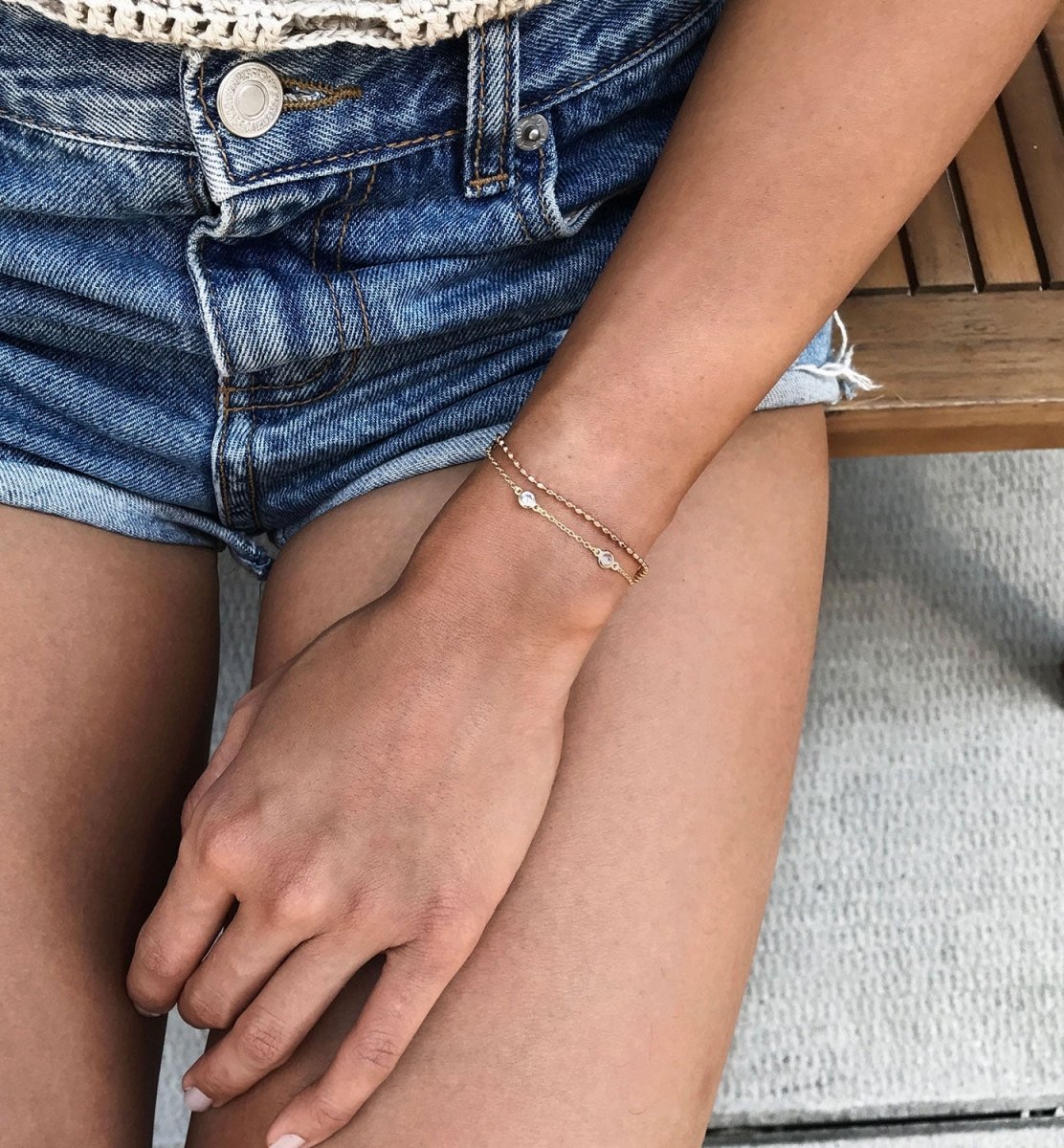 Rose gold vermeil beaded chain bracelet with clear stone stations, shown on a model's wrist