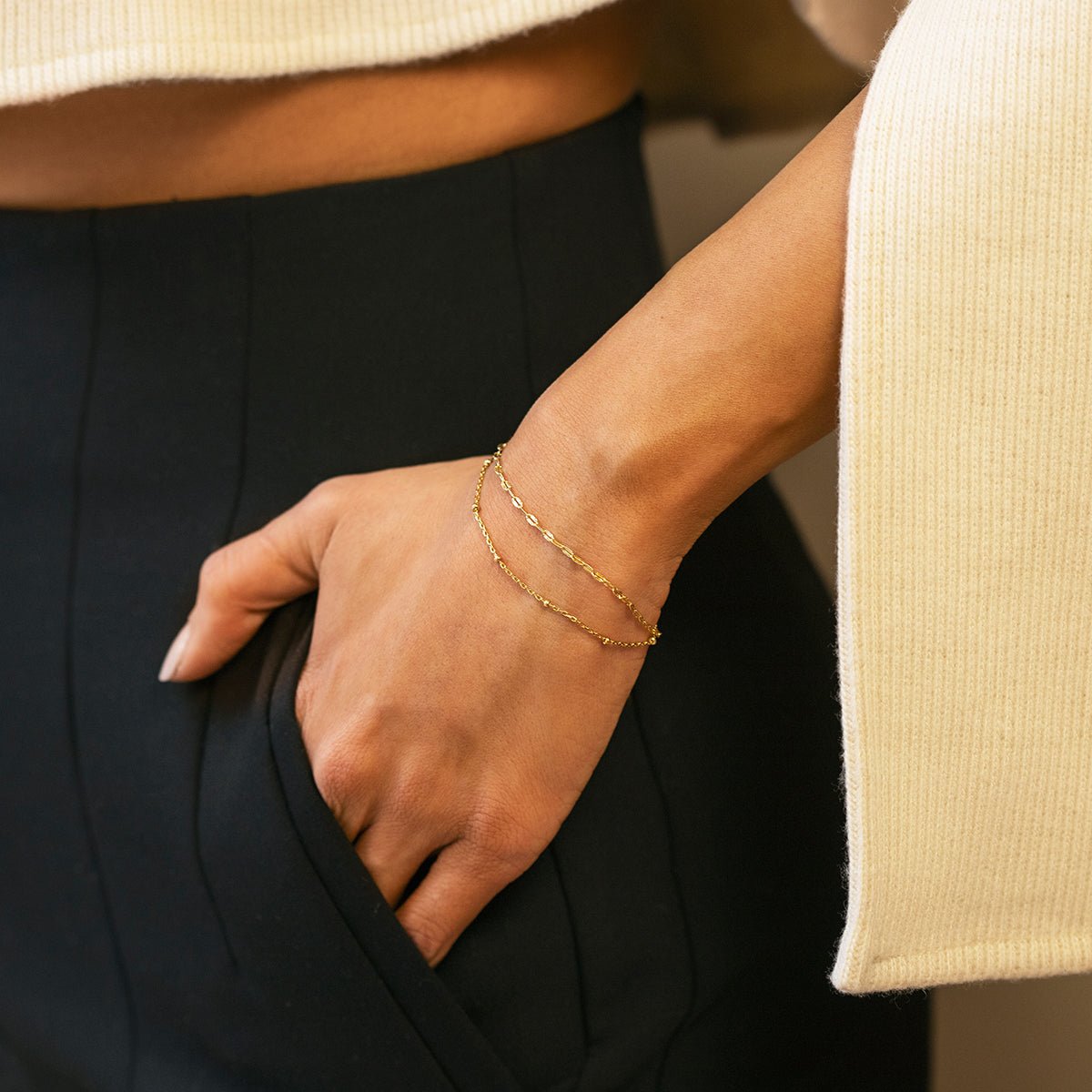 Gold vermeil double layered chain bracelet shown on a model's wrist, hand in a pocket