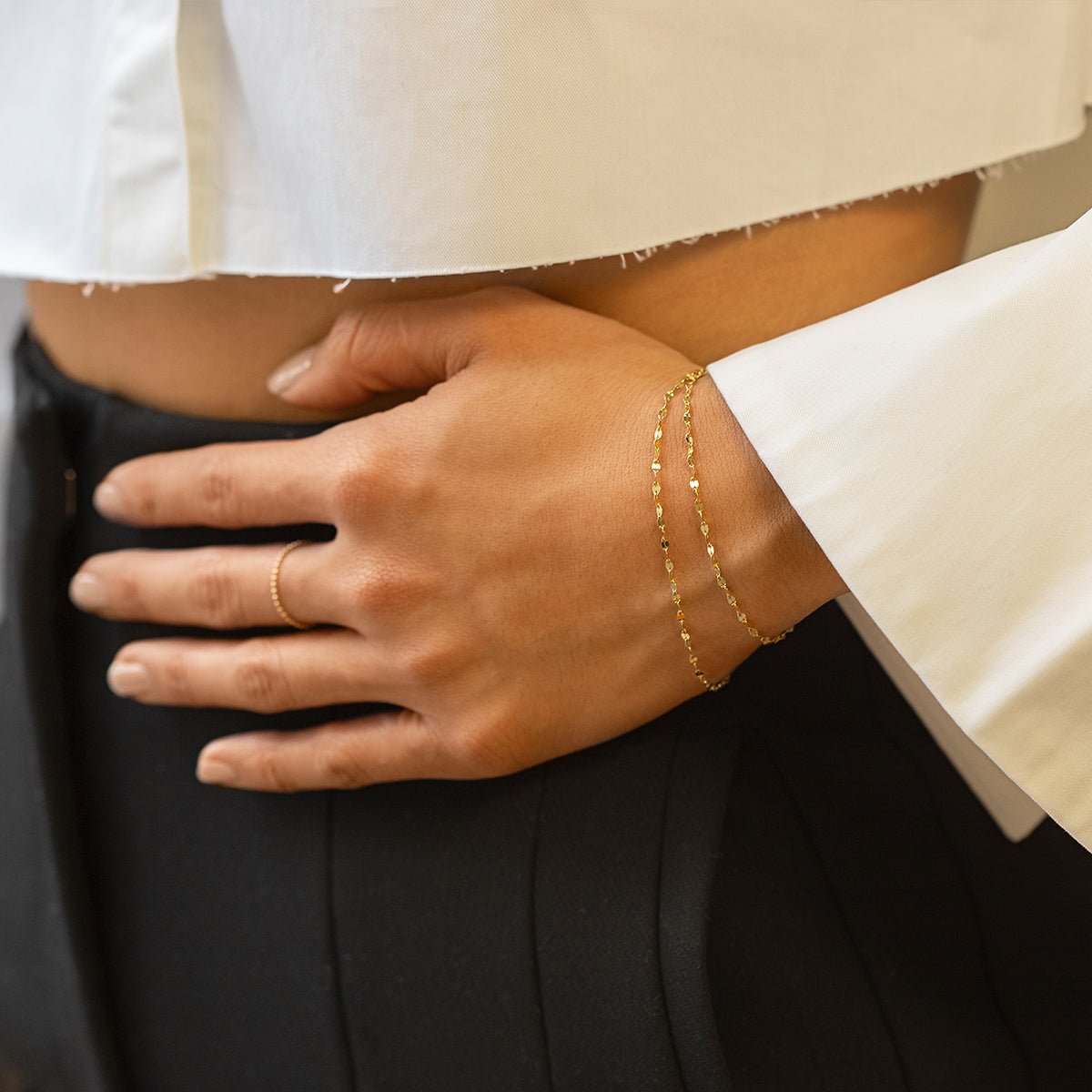 Sterling silver layered mirror-link chain bracelet set shown on a model's wrist at the hip