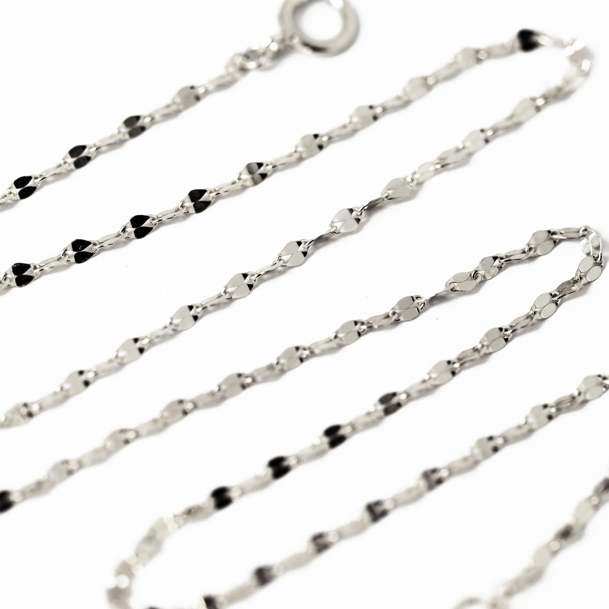 Sterling silver layered mirror-link chain bracelet set with a spring-ring clasp, on a white background