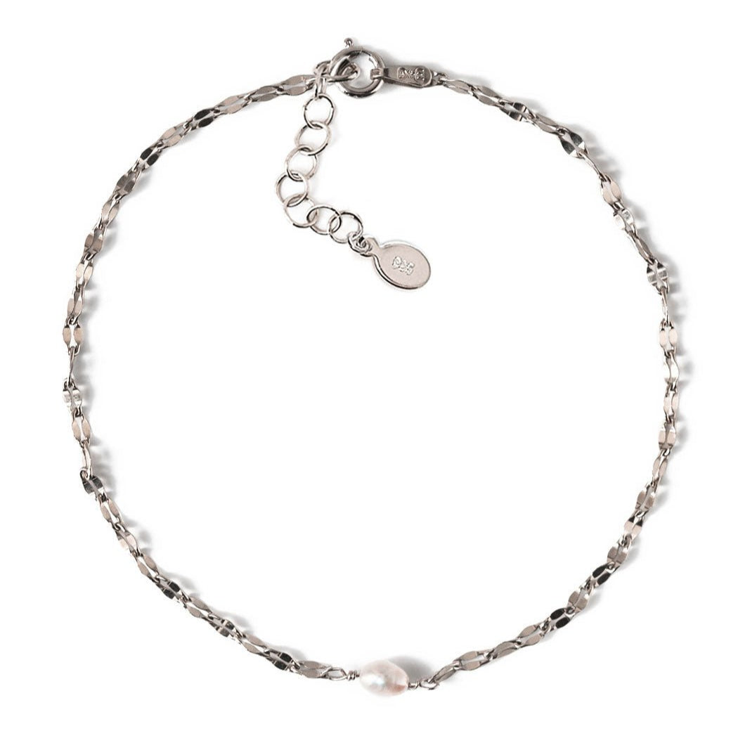 Sterling silver mirror-link chain bracelet with a single pearl, laid on a white background