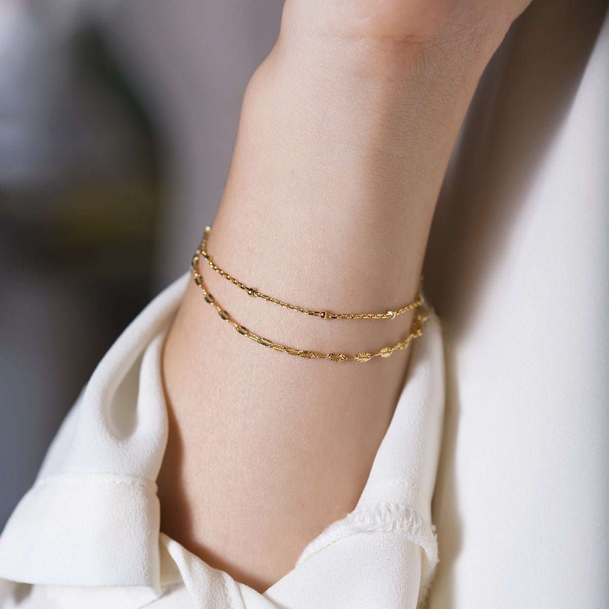 Gold vermeil double layered chain bracelet shown on a model's wrist with a white cuff