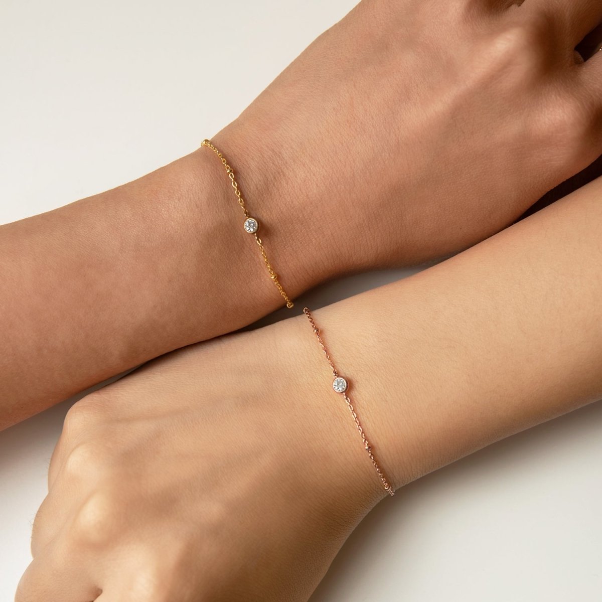 Rose gold vermeil crystal chain bracelet shown beside a gold version on two model's wrists