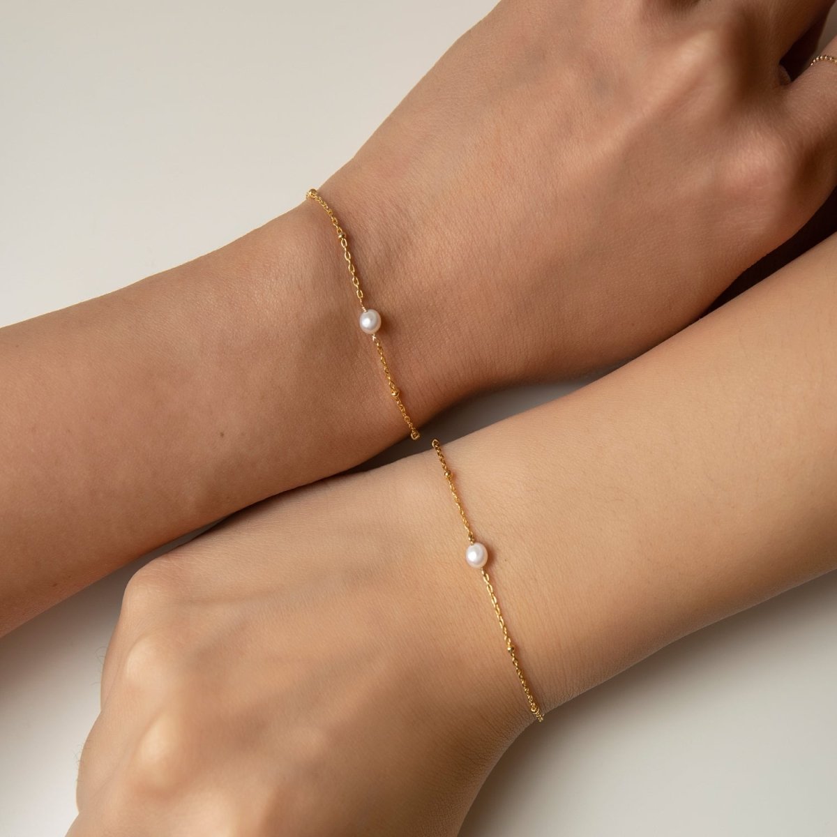 Rose gold vermeil pearl beaded chain bracelets shown on two wrists side by side