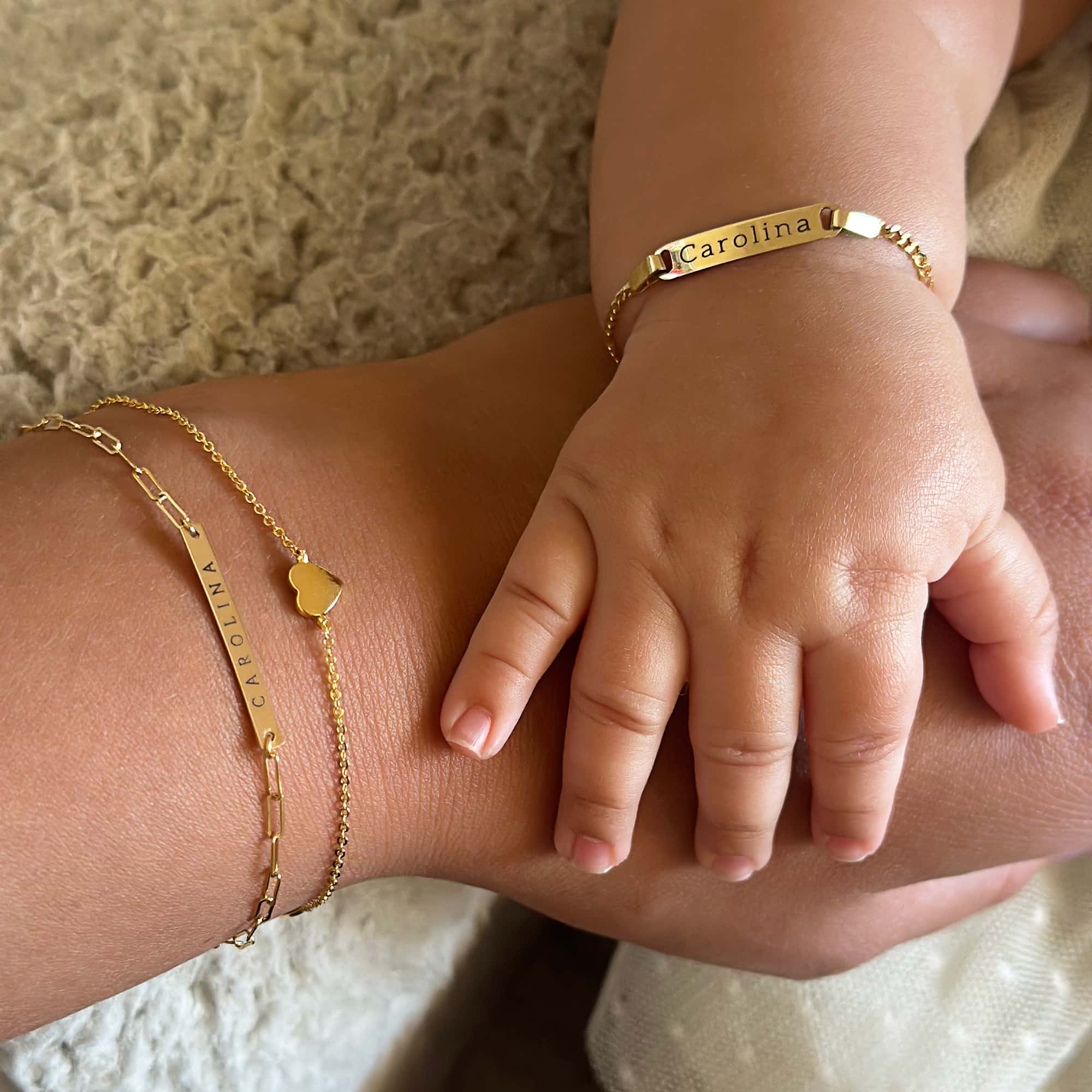 14K gold ID bracelet engraved with a name, shown on a child's wrist held in an adult hand