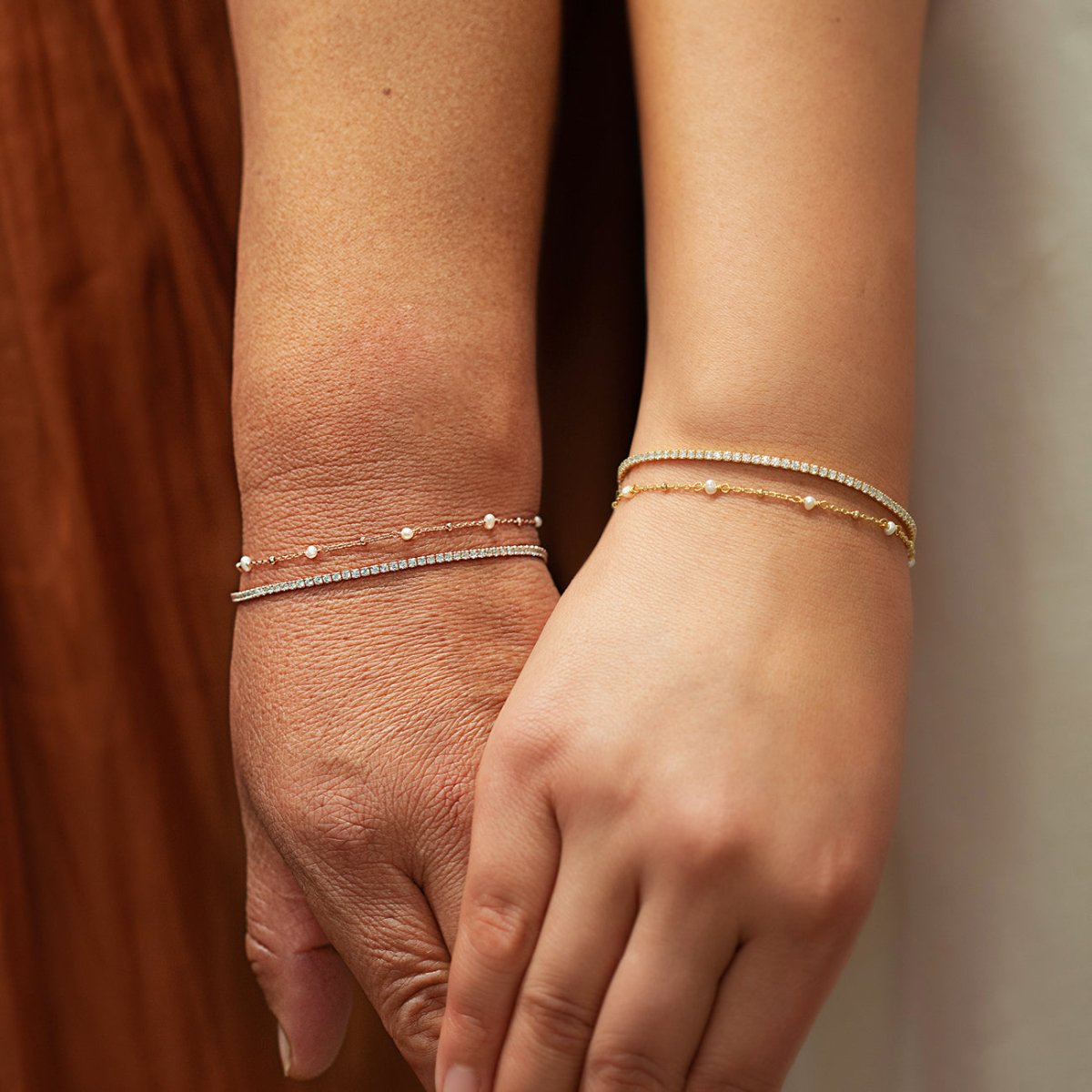 Rose gold vermeil dainty crystal line bracelet with white zirconia, shown layered on two models' wrists