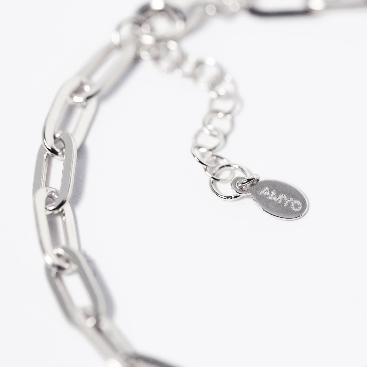Sterling silver paperclip chain bracelet with an extender chain and oval tag, close-up detail