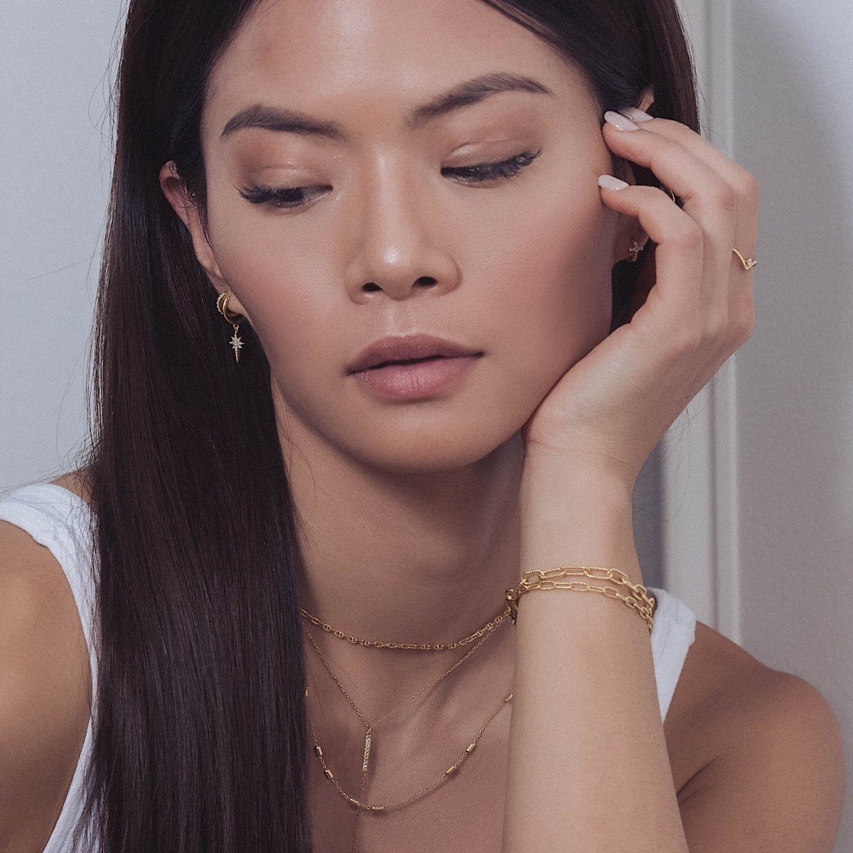 Gold vermeil oval link chain bracelet layered on the wrist, shown on a model with necklaces