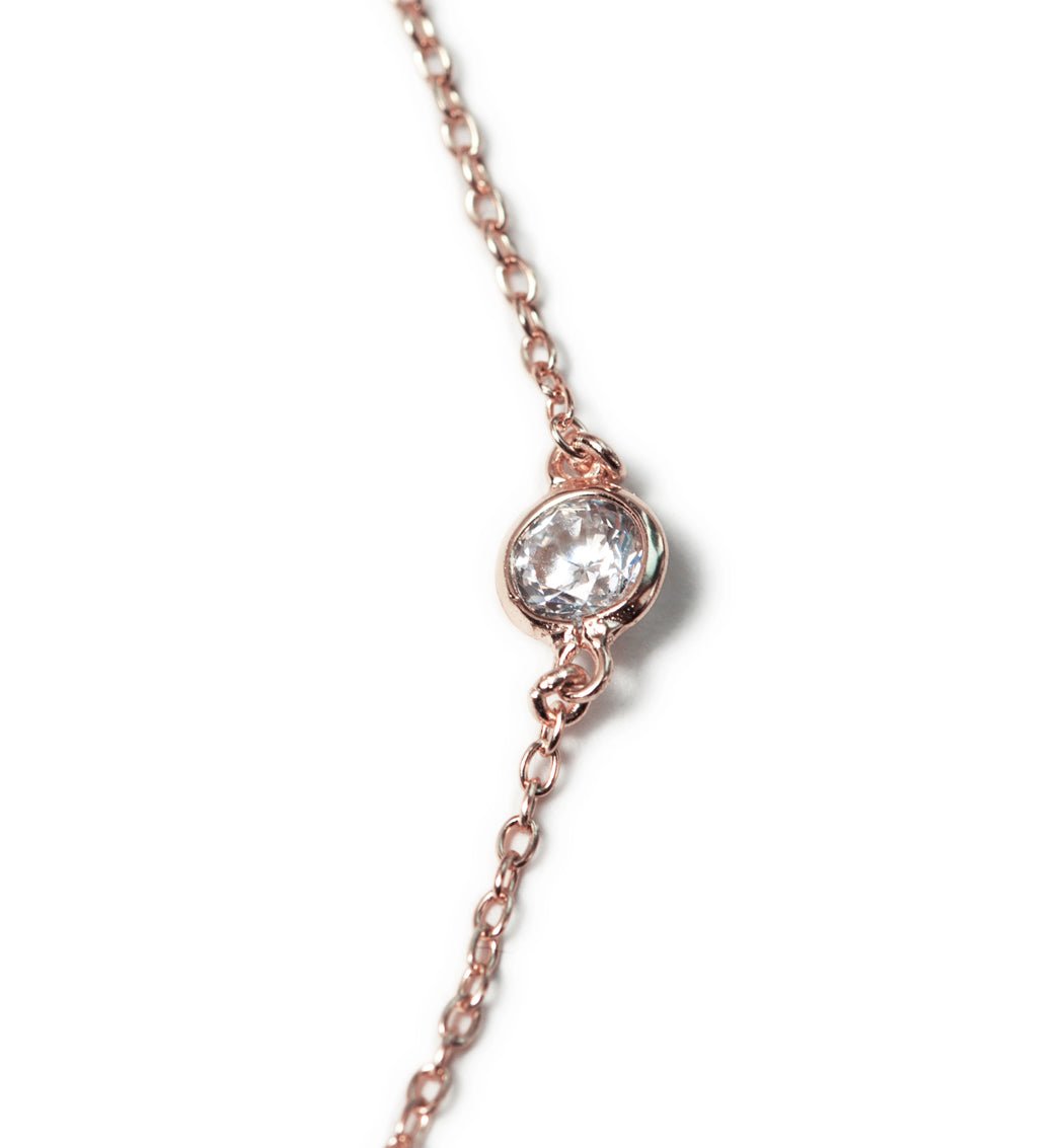 Rose gold vermeil station bracelet with a round bezel-set white zirconia, close-up detail