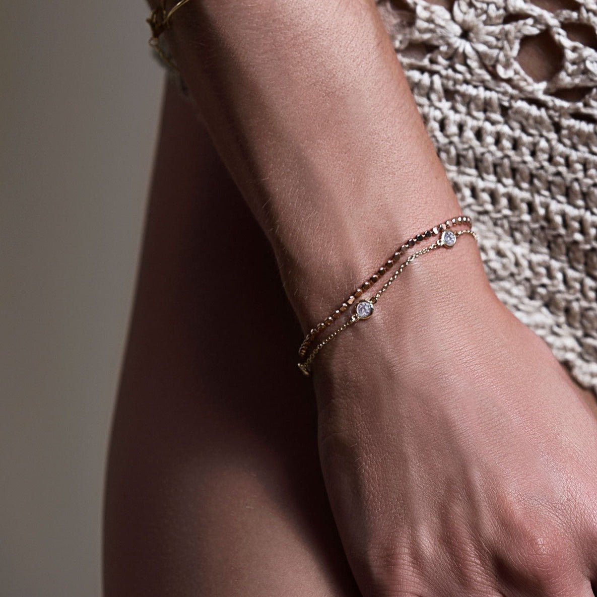 Gold vermeil beaded chain bracelet shown layered on a model's wrist with a crochet top