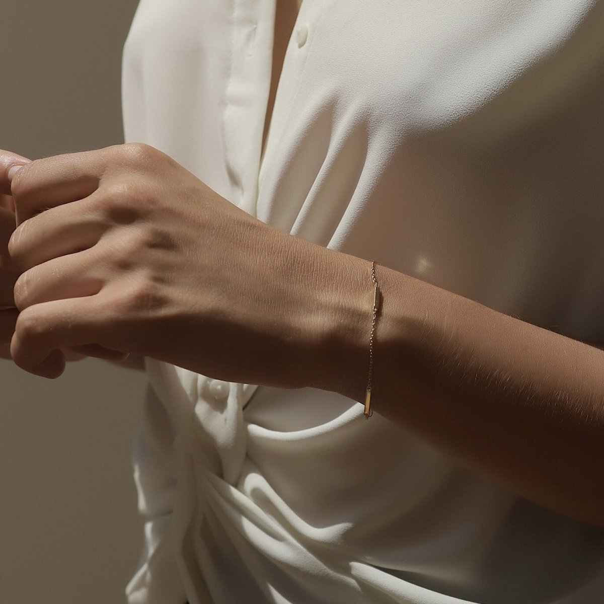 Gold vermeil eternity bar bracelet on a thin chain, shown on a model's wrist