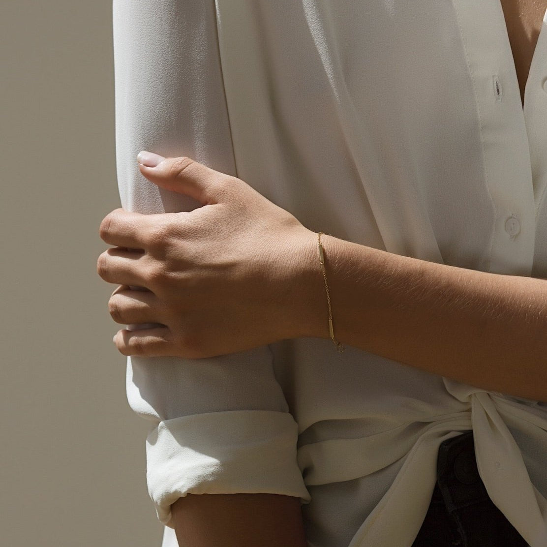 Sterling silver eternity bar bracelet on a thin chain, shown on a model's wrist