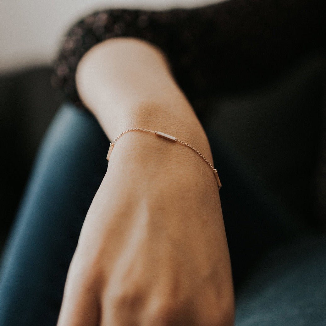 Gold vermeil eternity bar bracelet with a slim bar, close-up on a model's wrist