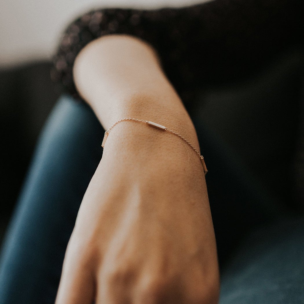 Rose gold vermeil eternity bar bracelet on a fine chain, shown on a model's wrist