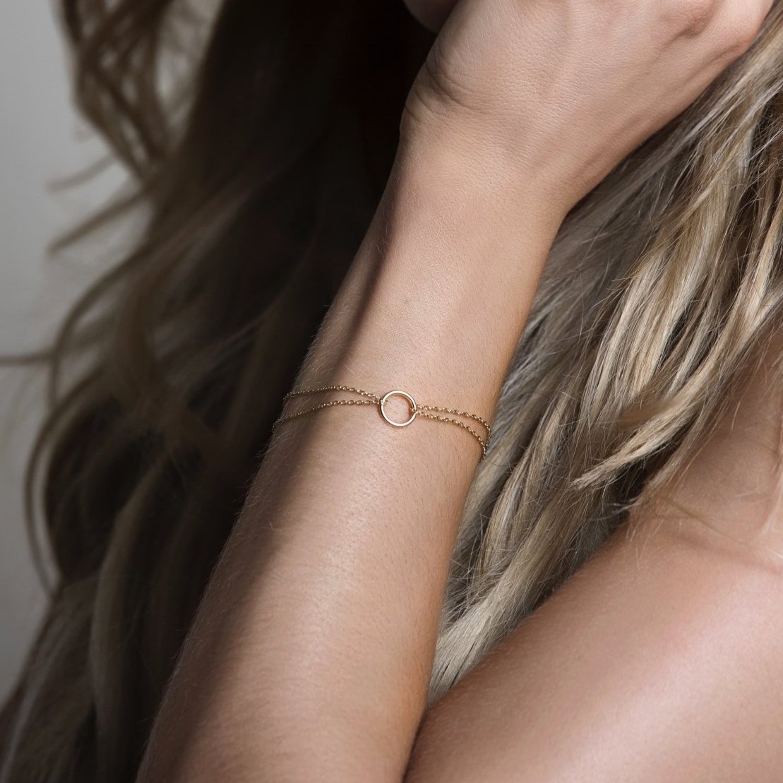 Gold vermeil eternity circle bracelet with an open ring on a double chain, shown on a wrist