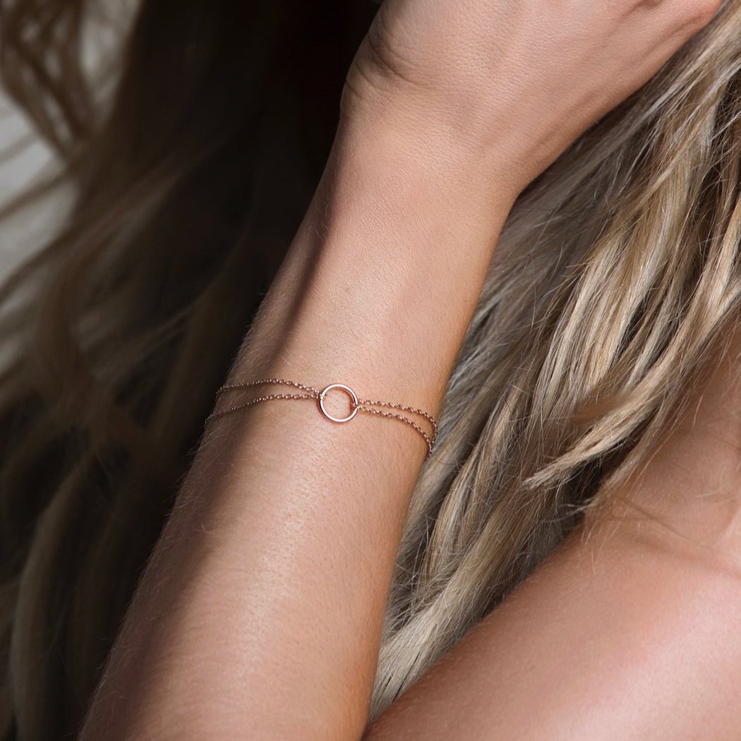 Sterling silver eternity circle bracelet on a double chain, shown on a model's wrist