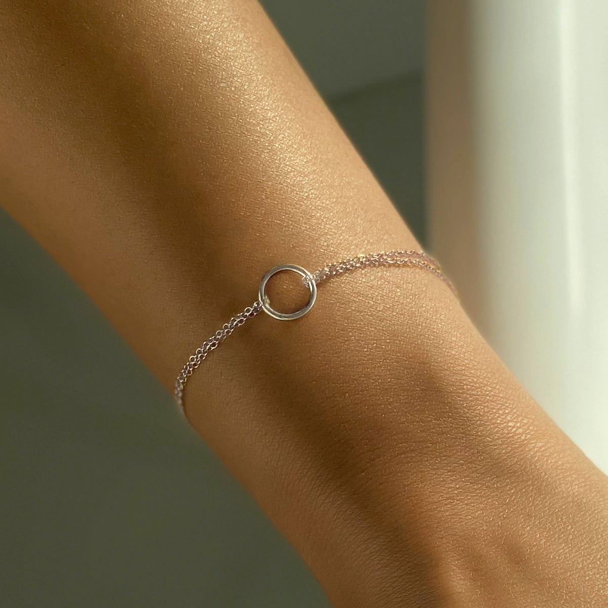 Sterling silver eternity circle bracelet with an open ring on a double chain, shown on a wrist