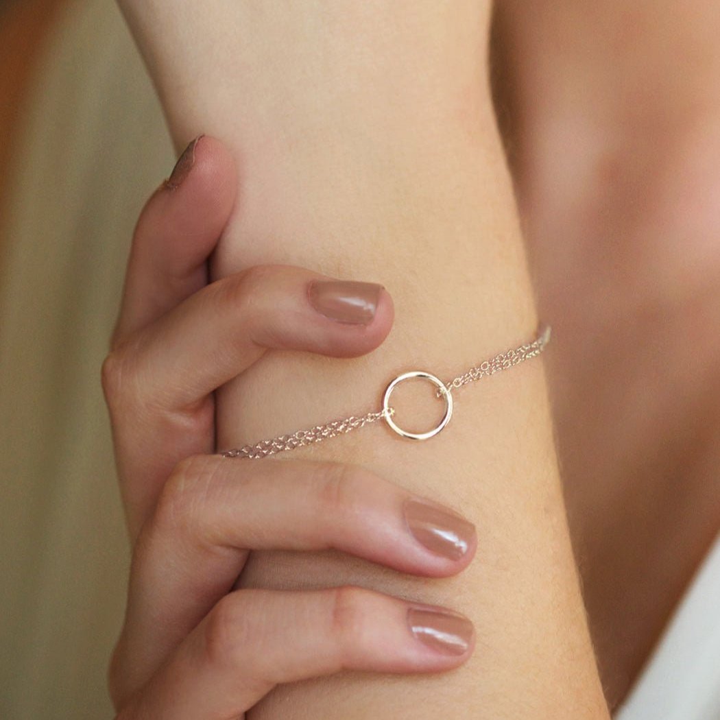 Sterling silver eternity circle bracelet shown on a wrist against the model's hair
