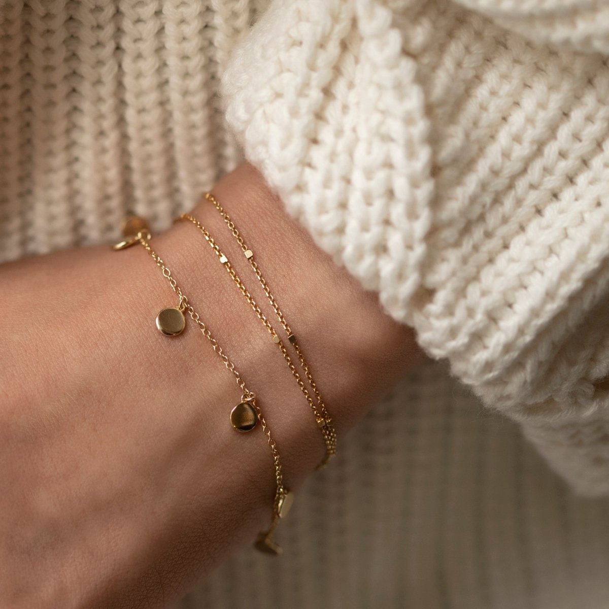 Gold vermeil disc dangle bracelet shown layered with another chain on a model's wrist