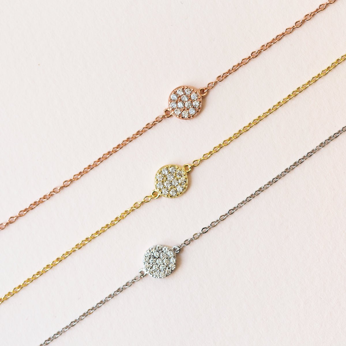 Gold vermeil pavé disc chain bracelet with white zirconia, three tones laid on a cream background