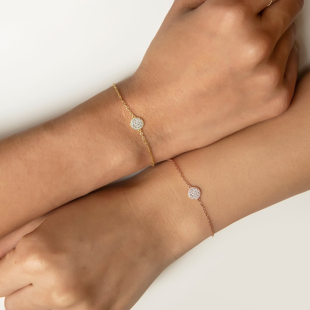 Gold vermeil and rose gold pavé disc chain bracelets with white zirconia, shown on two wrists