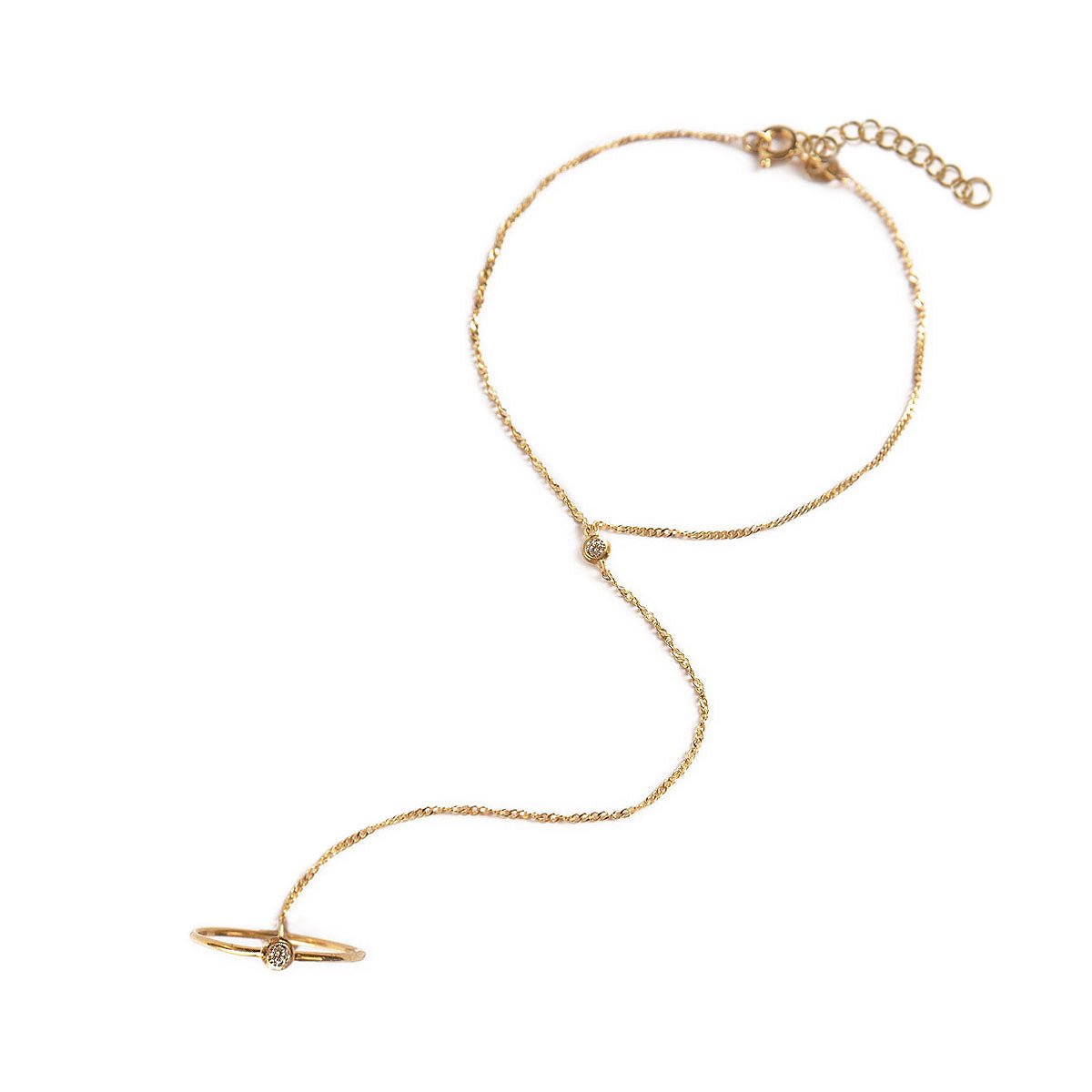 Gold vermeil ring-to-bracelet handchain with a bezel-set clear stone, laid on a white background