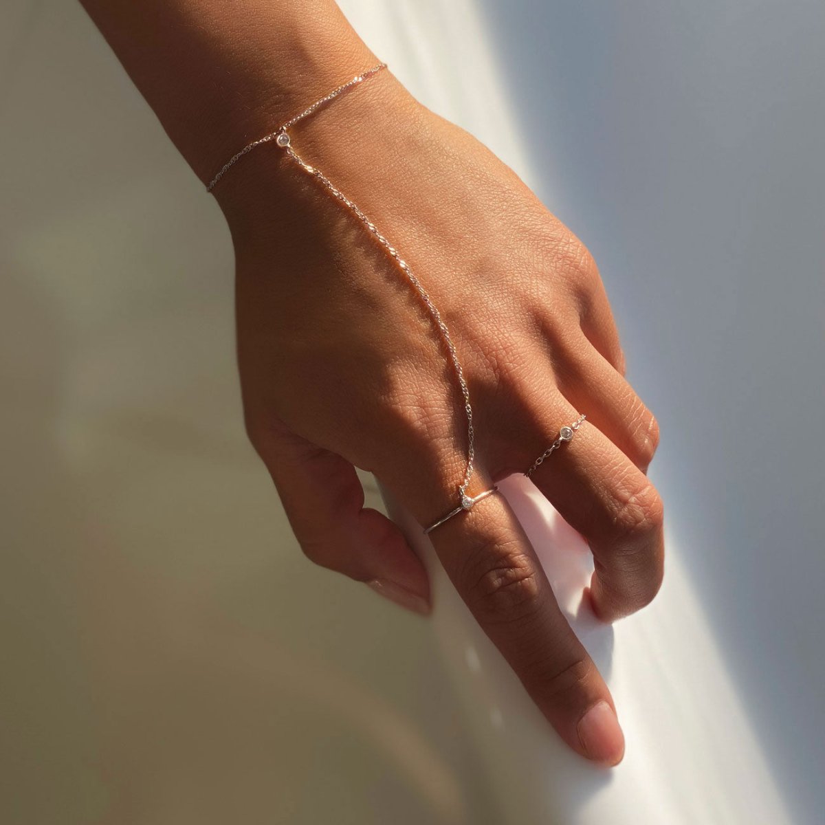 14K white gold chain ring and hand chain with clear stones, shown on a model's hand