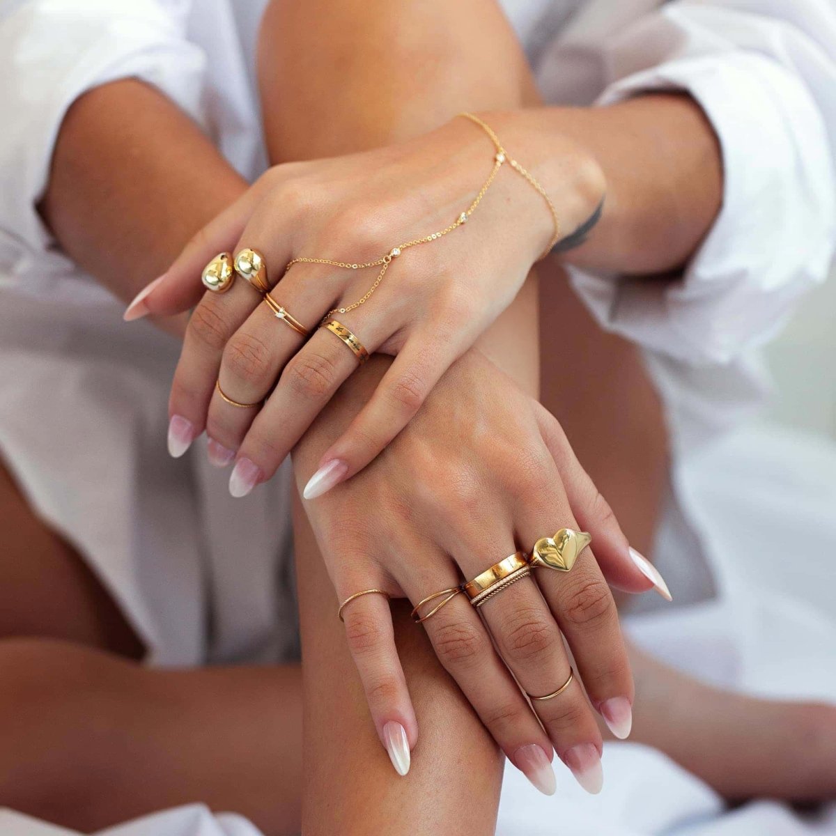 Gold-filled thin band and rope ring set shown stacked among rings on a model's hands
