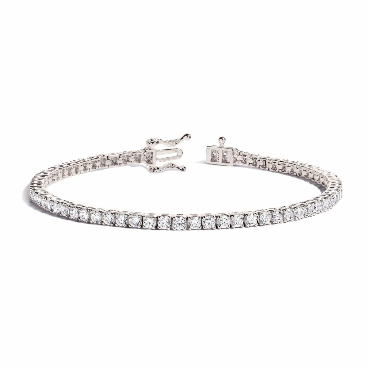 14K white gold diamond tennis bracelet with round stones and a box clasp, on a white background