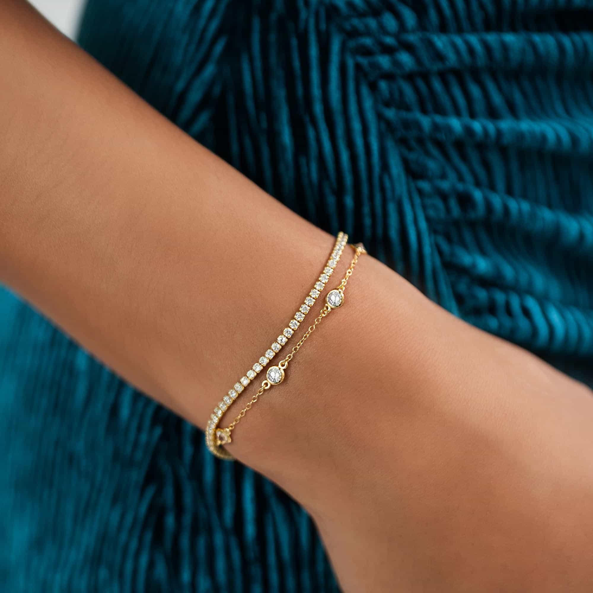 Gold vermeil white zirconia station bracelet shown layered on a model's wrist
