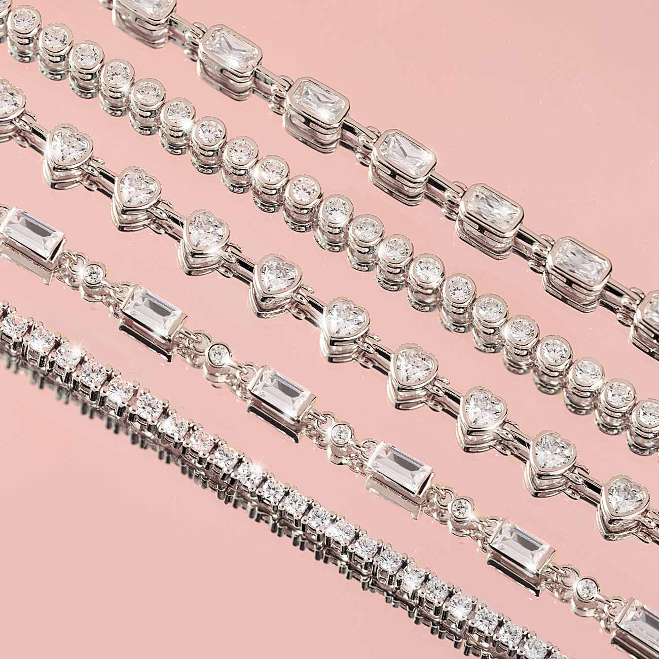 Silver tennis bracelets with mixed-cut clear stones, close-up detail on pink
