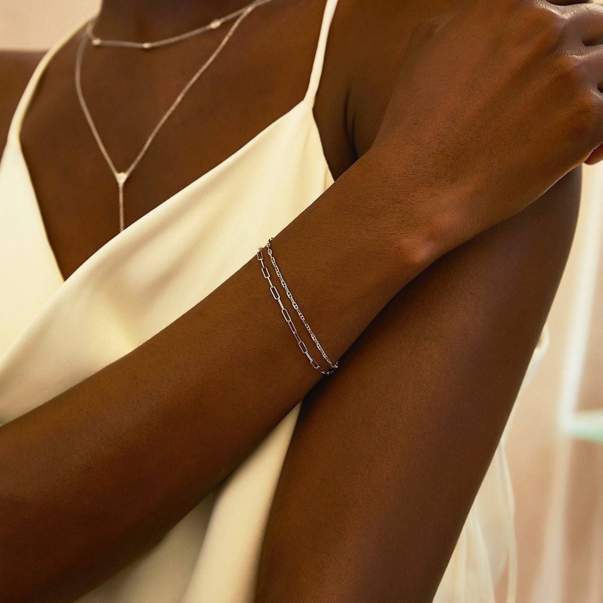 14K white gold paperclip chain bracelet shown doubled on a model's wrist