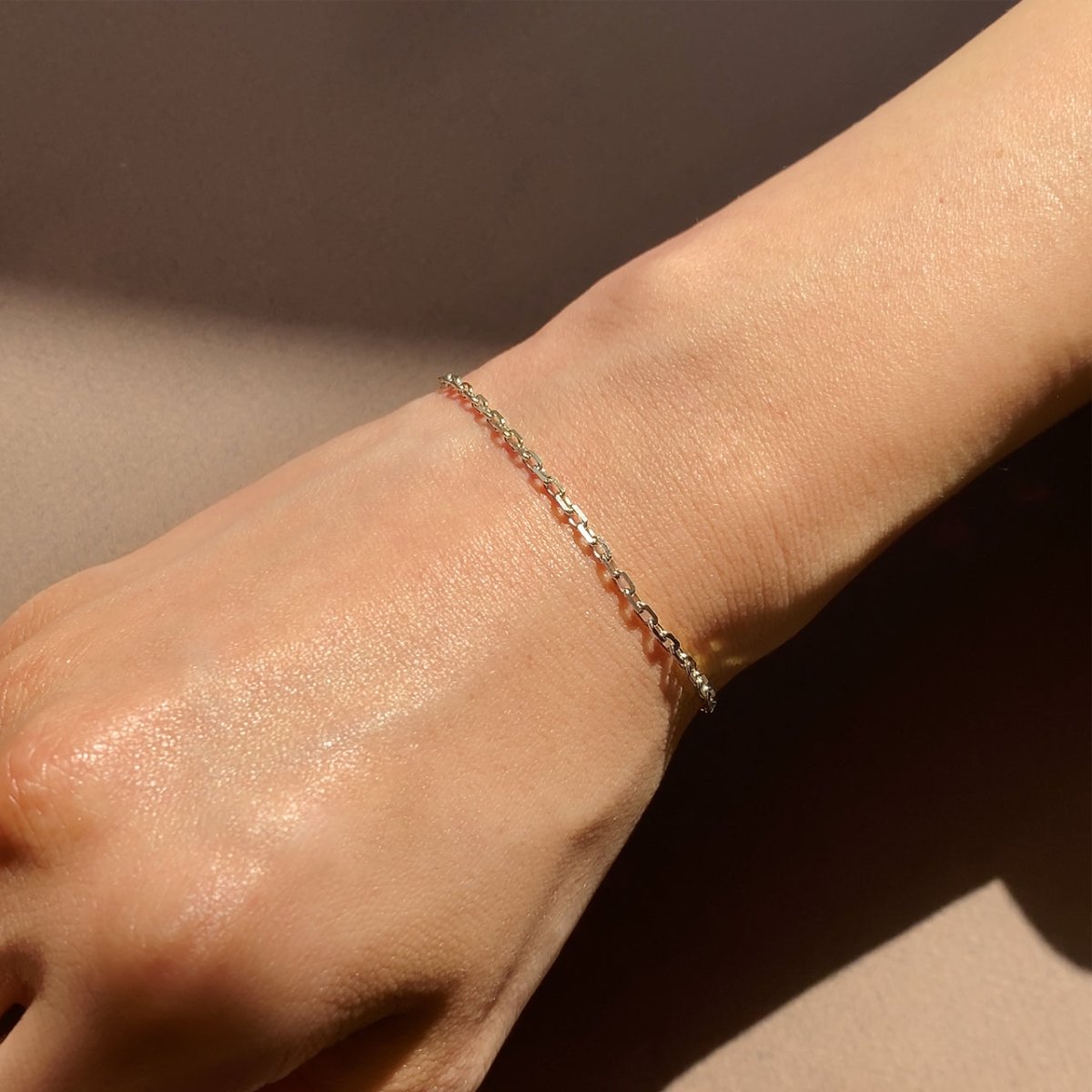 14K white gold cable chain bracelet shown on a model's wrist