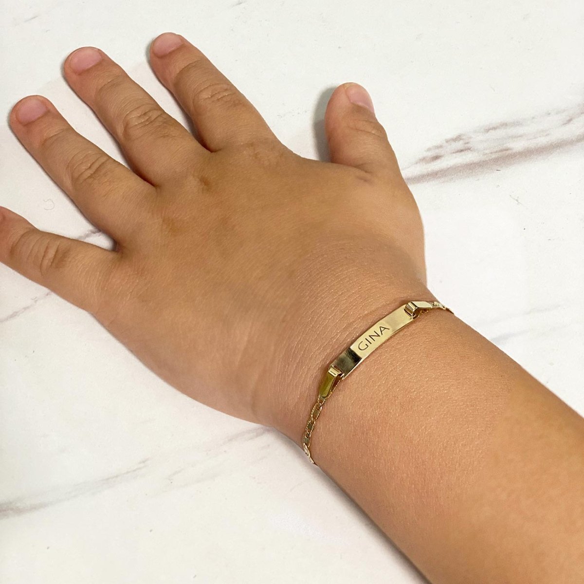 14K gold flat mariner-link ID bracelet engraved name, shown on a child's wrist