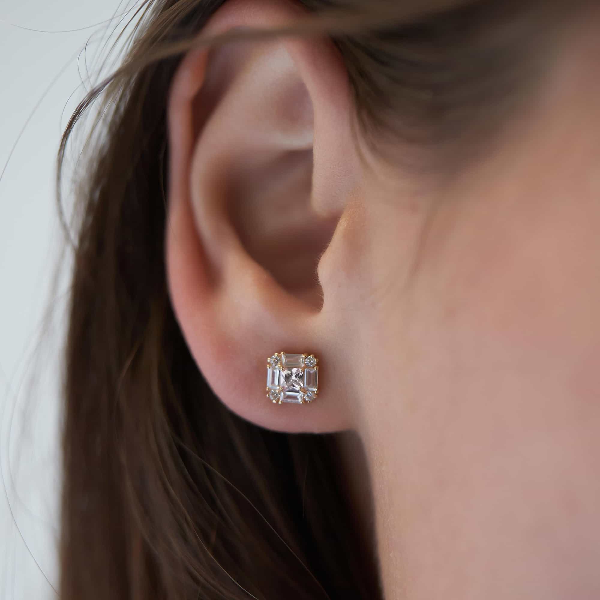 14K gold deco stud with clear white zirconia baguette and round stones, shown on a model's ear