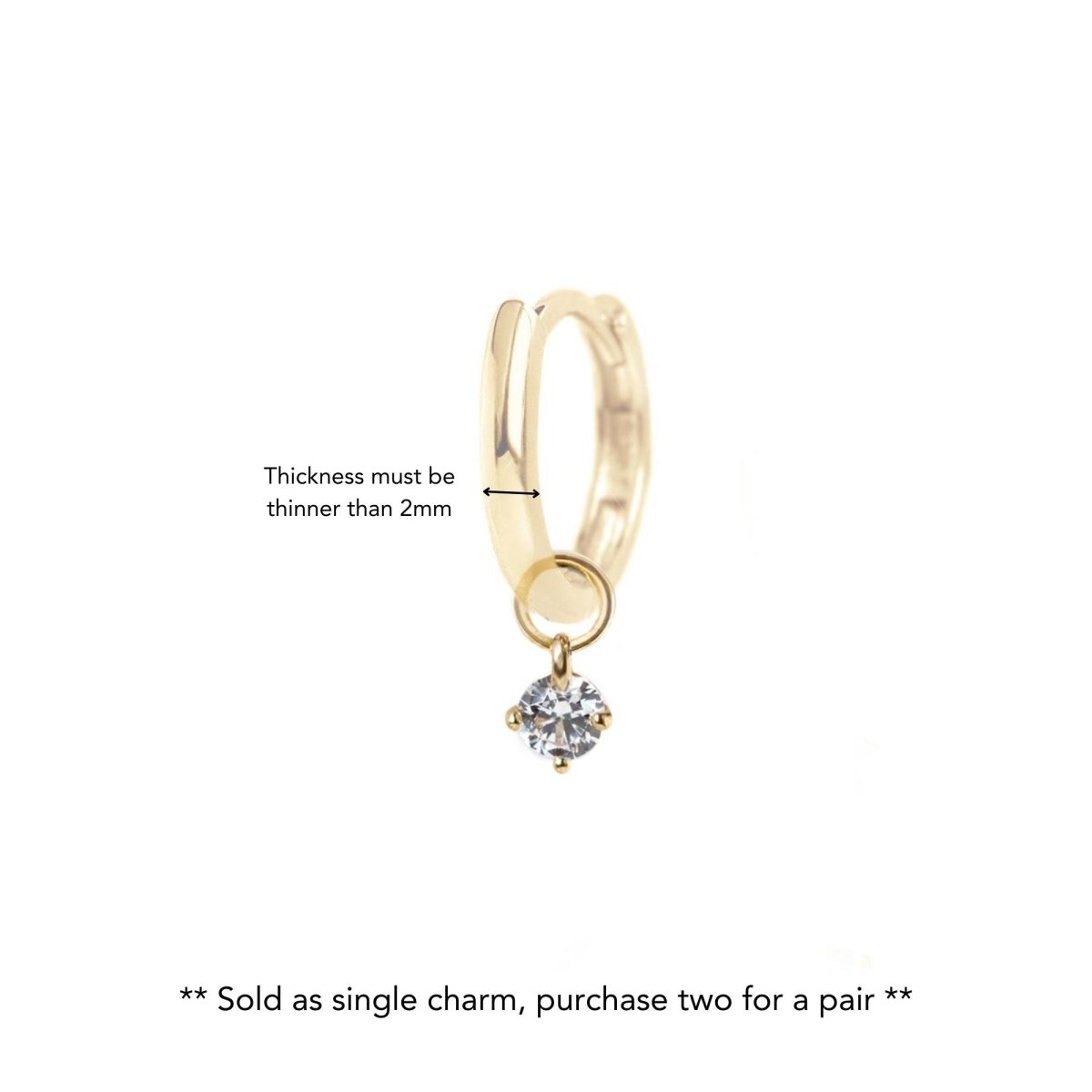 14K gold tiny charm with a round clear stone hung on a gold huggie hoop, with a size note, on a white background