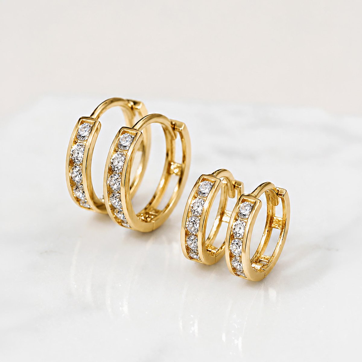 Pair of 14K gold pavé huggie hoops shown in a close-up.