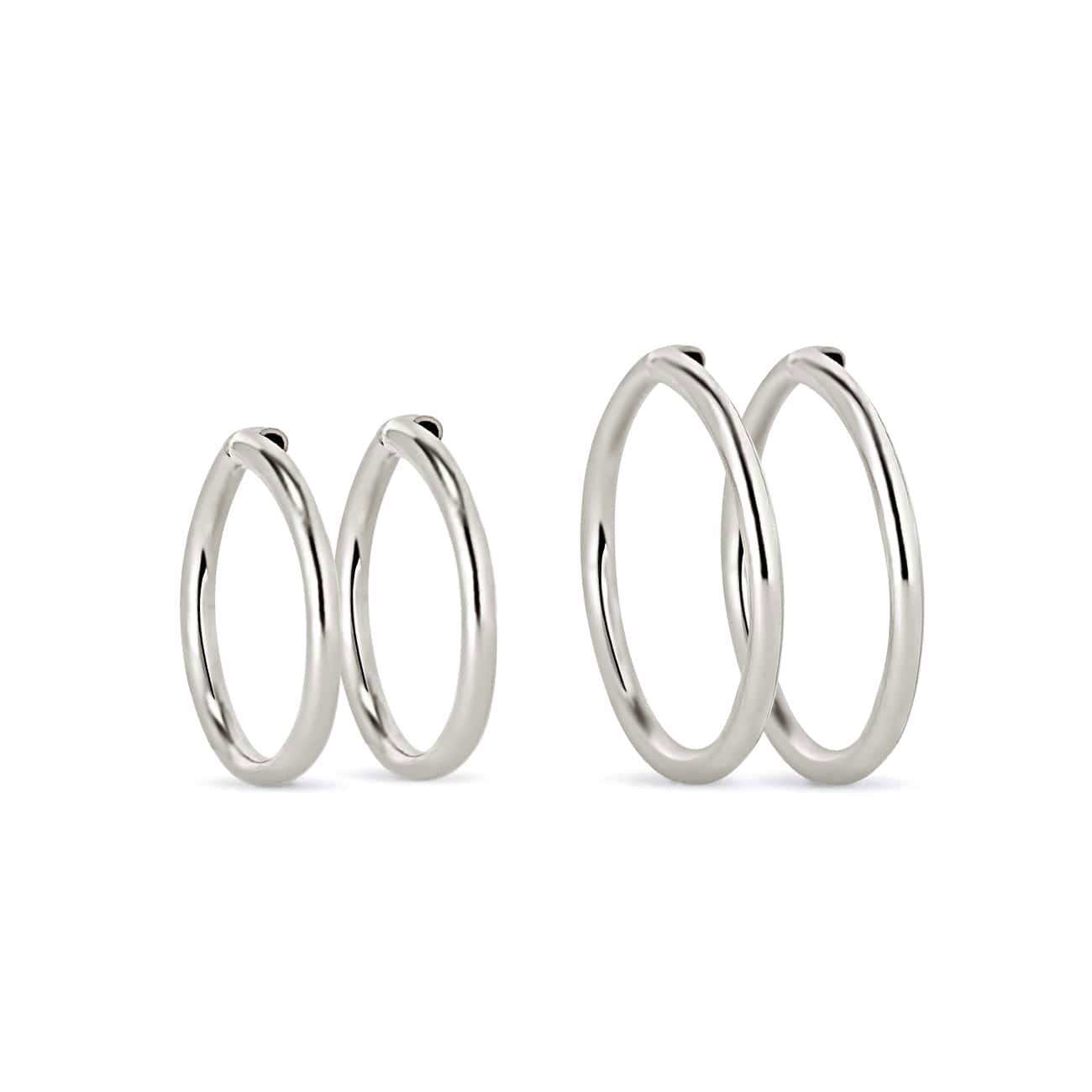 Sterling silver thin endless huggie hoops in two sizes, on a white background