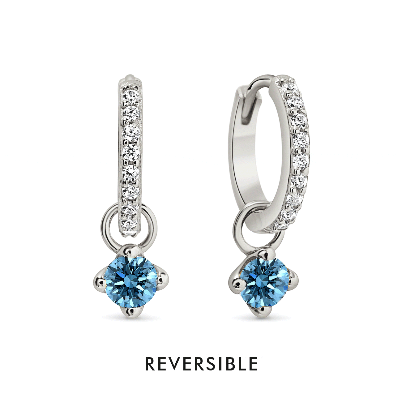 Sterling silver pavé huggie hoops with a dangling round blue zircon charm, on a white background
