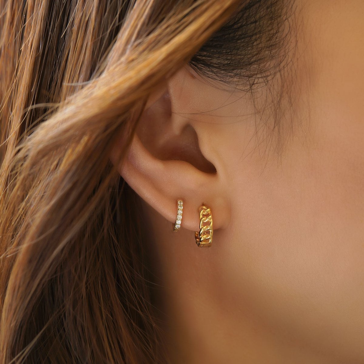 Gold vermeil Cuban curb chain-link huggie hoop shown on a model's lobe