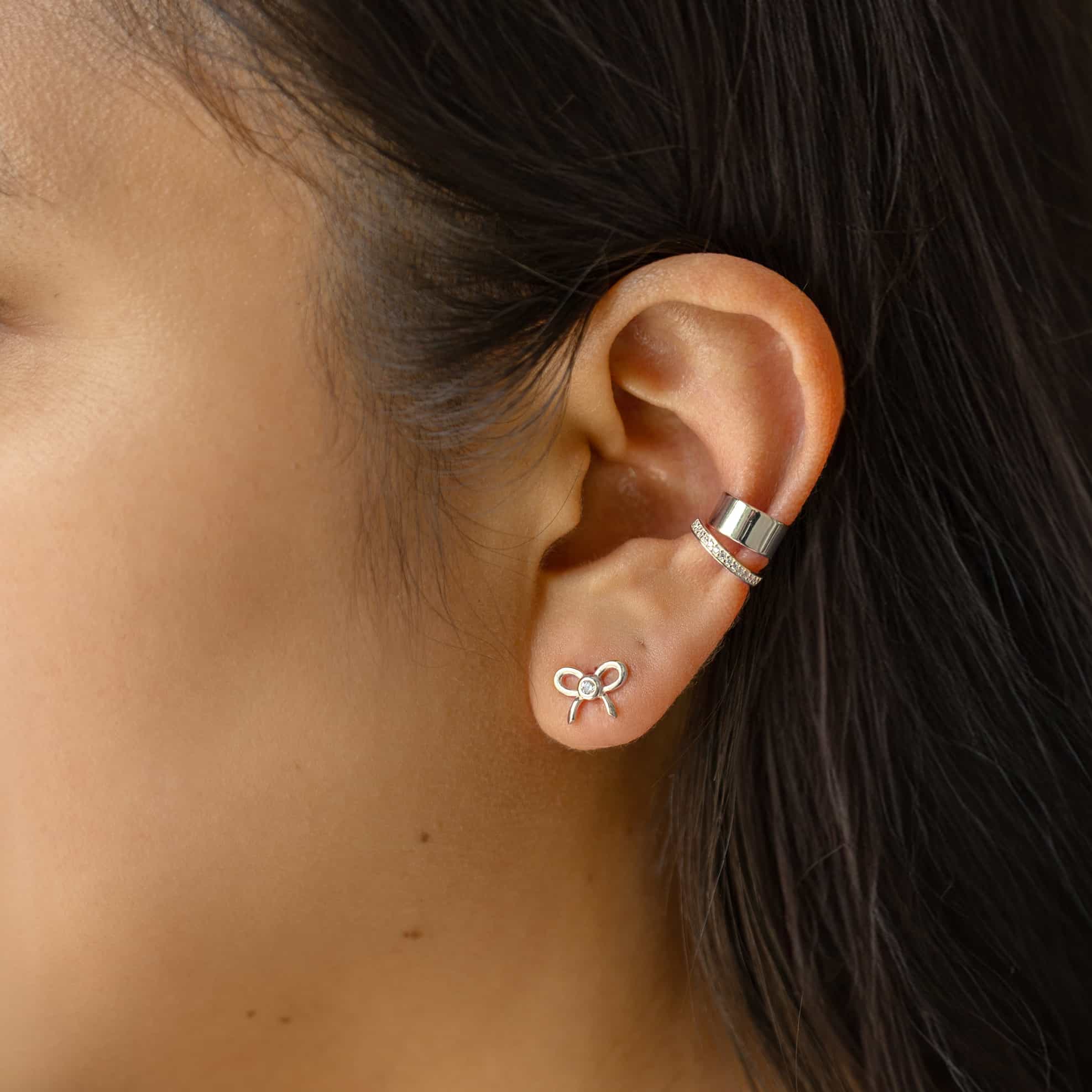Silver bow stud and a wide ear cuff with a thin pave cuff styled on a model's ear