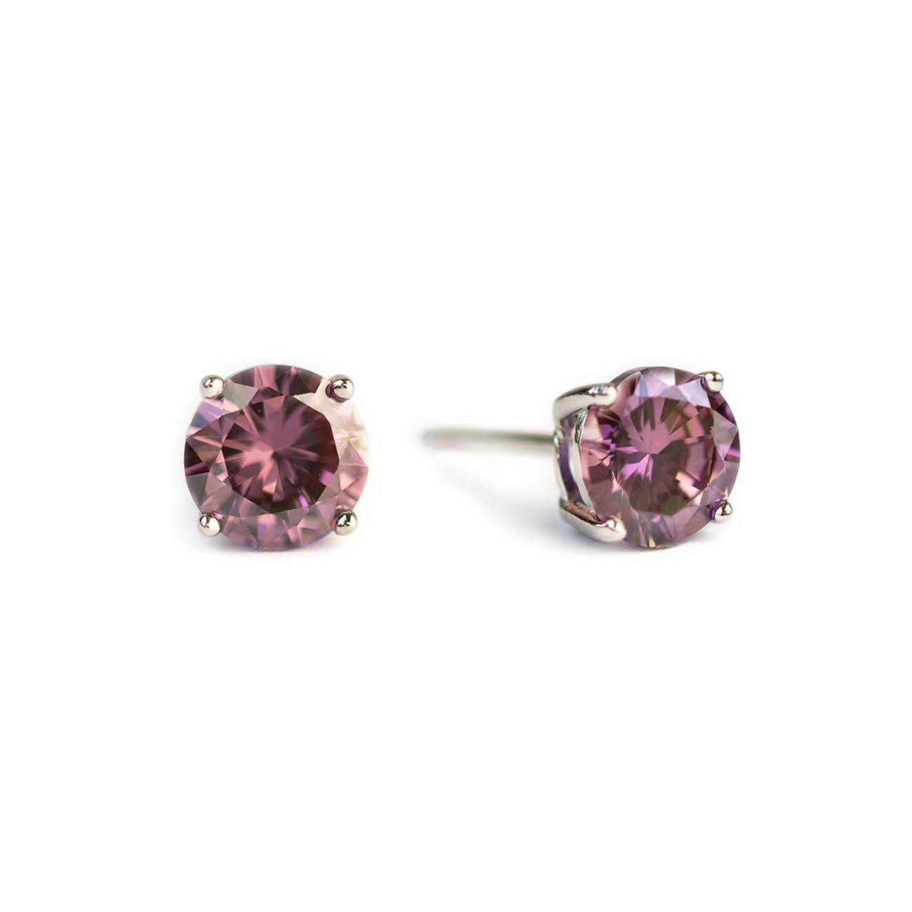 Pair of sterling silver alexandrite studs with round purple-pink stones, on a white background