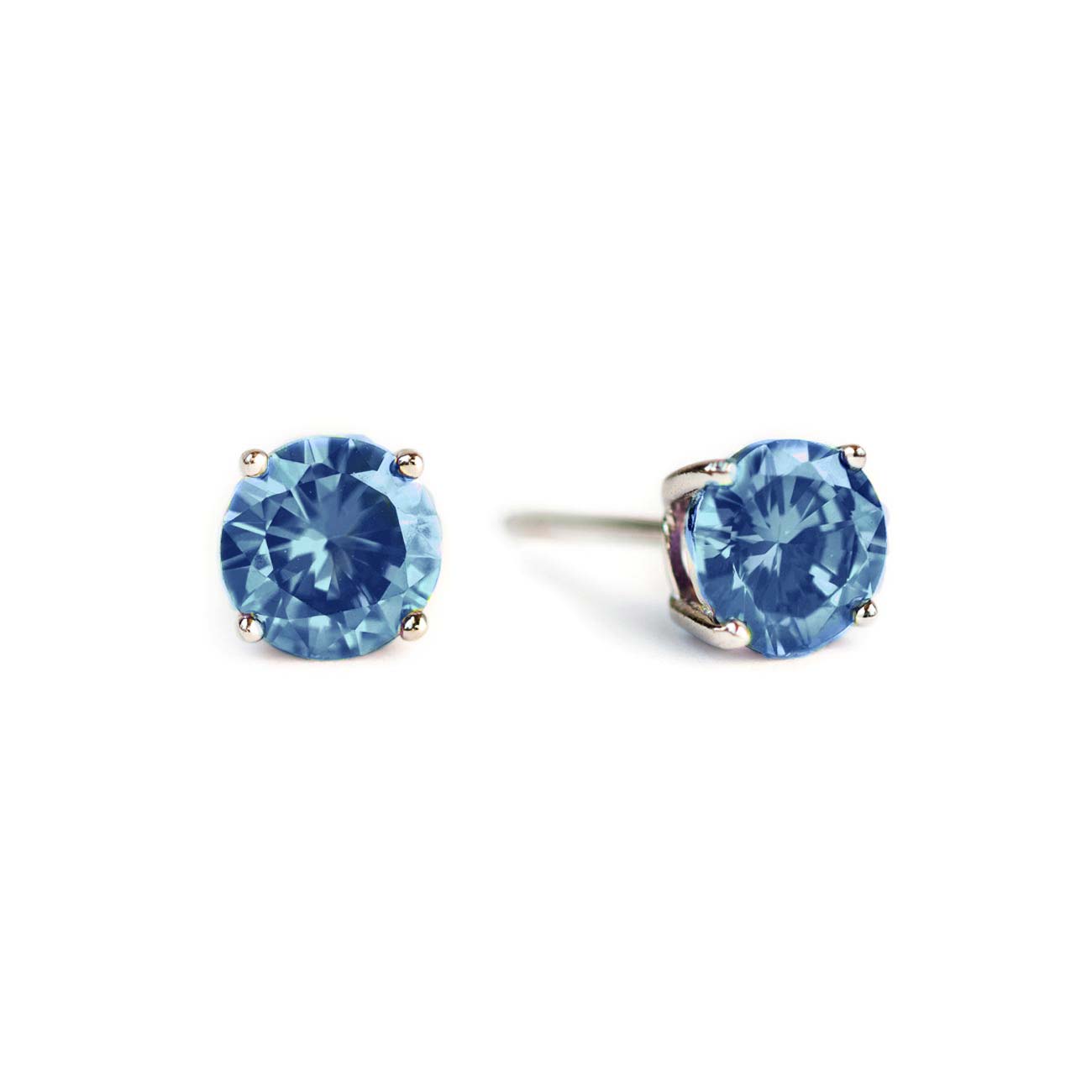 Pair of sterling silver blue zircon studs with round light blue stones, on a white background